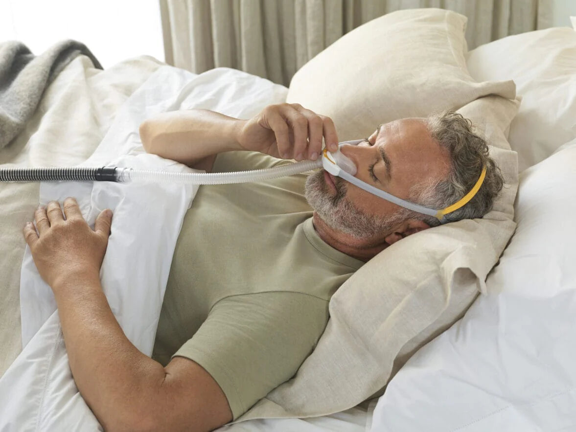 Man in bed wearing F&P Solo Pillow Mask 