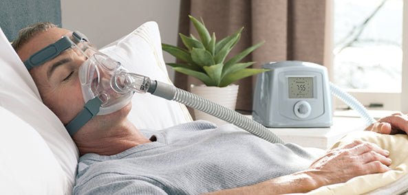 Man lays in bed wearing Fisher and Paykel Simplus Full Face mask