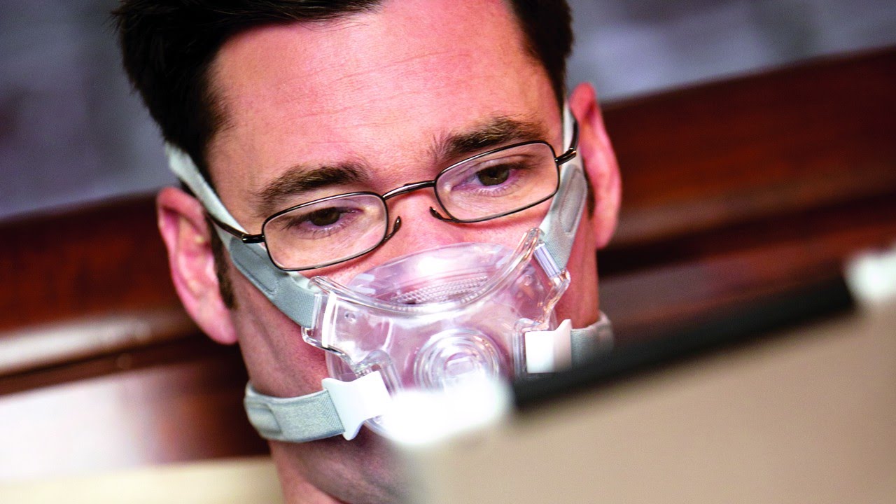 A man wearing reading glasses wearing the Philips Amara View full face Mask