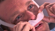 Load image into Gallery viewer, Man putting on Philips Respironics DreamWear under the nose mask